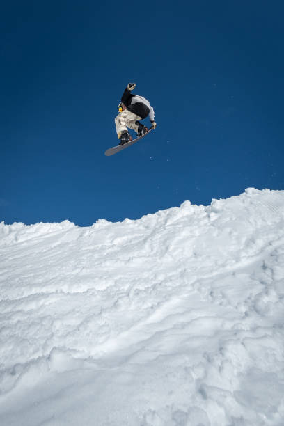 istock Snowboarder jumping against blue sky 889231170