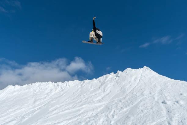 istock Snowboarder jumping against blue sky 889231300