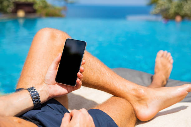 istock Man with mobile phone by the pool 889258374