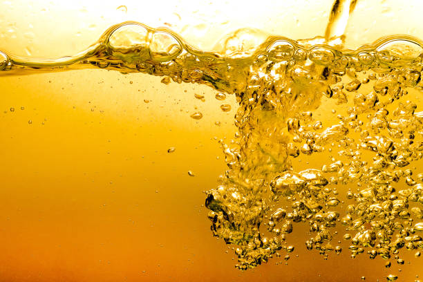 burbujas en el fondo abstracto de agua aceite cerveza oro hermoso - splashing orange fruit water fotografías e imágenes de stock