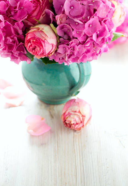 istock beautiful pink roses and hydrangea in vase on wooden table 889281468