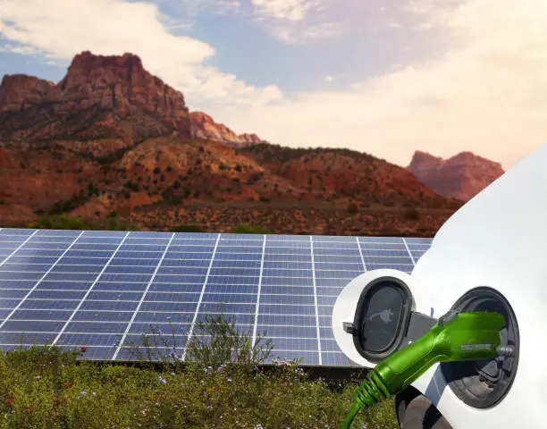 Close up view of Electric Car charging and solar panels in the background