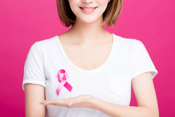 woman hand showing pink breast cancer awareness ribbon - aids awareness ribbon imagens e fotografias de stock