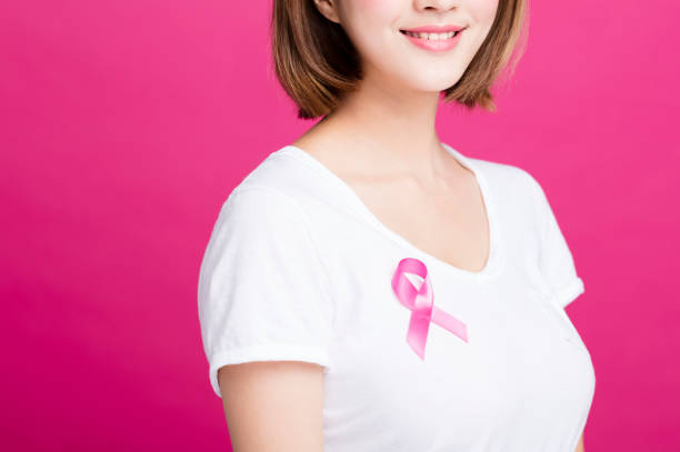 woman showing pink breast cancer awareness ribbon - aids awareness ribbon imagens e fotografias de stock