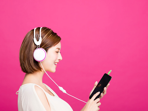 woman listening music with headphones and smart phone