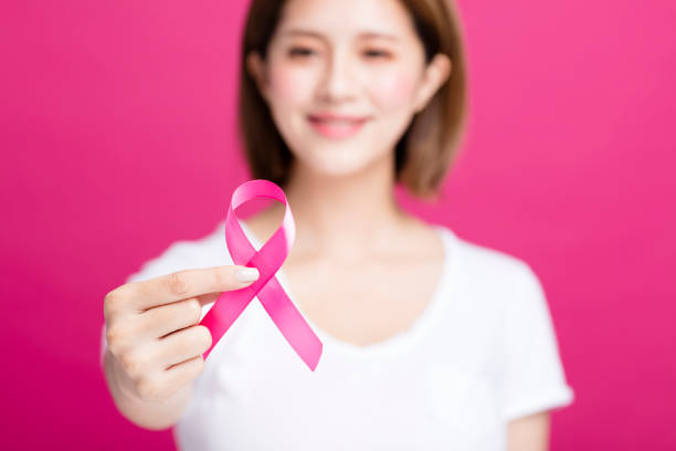 woman hand showing pink breast cancer awareness ribbon - aids awareness ribbon imagens e fotografias de stock