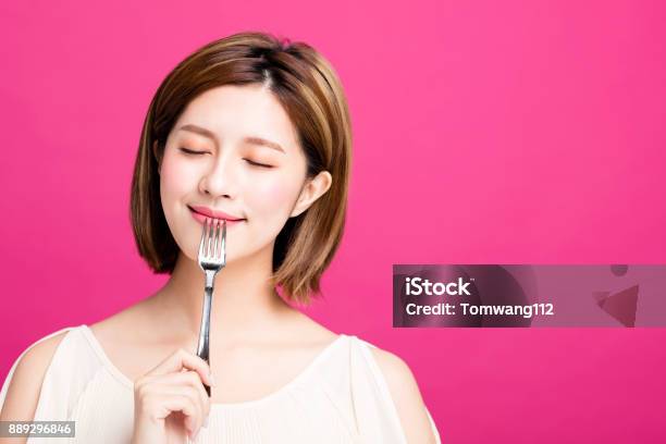 Young Woman Holding Fork And Enjoy Tasty Food Stock Photo - Download Image Now - Eating, Women, Fork