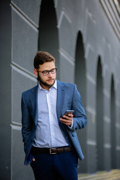 istock Young businessman typing message outdoors 889297026
