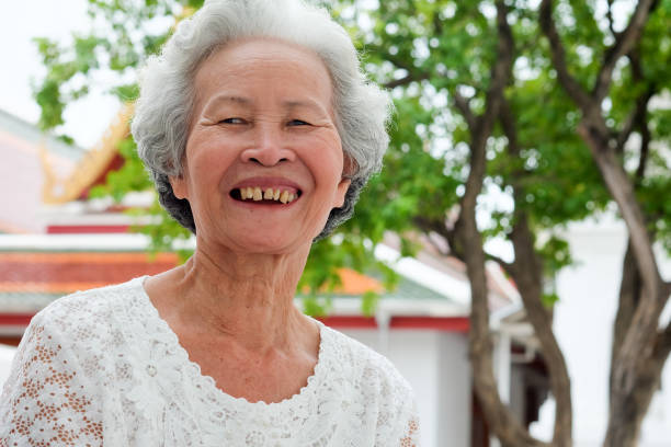 ältere asiatische frauen mit grauen haaren haben lächelnde gesichter. - underdeveloped stock-fotos und bilder