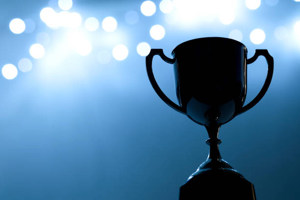 istock Silver Trophy competition in the dark on the abstract blurred light background with copy space, Blue Tone 889312658