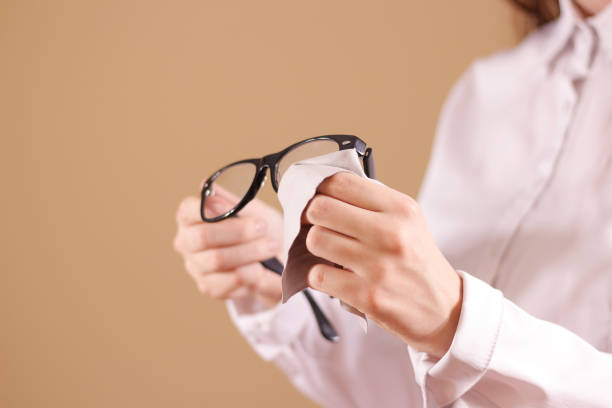 istock Women hand cleaning glasses lens with isolated background 889320792