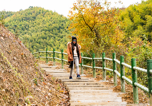 The young woman walk along the mountain path.