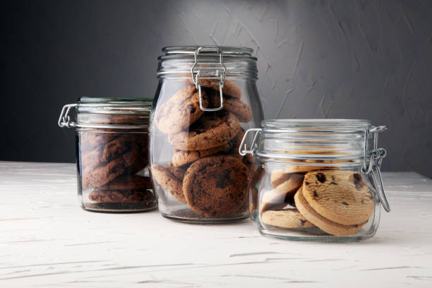 istock Chocolate cookies in a glass jar on white background 889323712