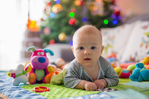 istock Happy three months old baby boy, playing at home on a colorful activity blanket 889362456