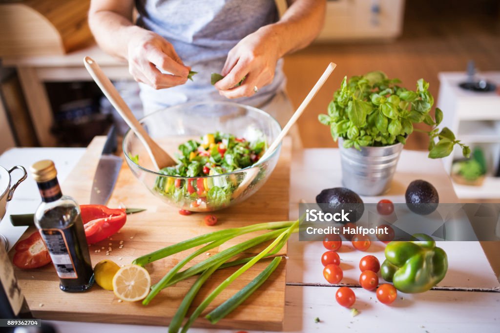 Unrecognizable man cooking. Unrecognizable man cooking. A man making vegetable salad. Making Stock Photo