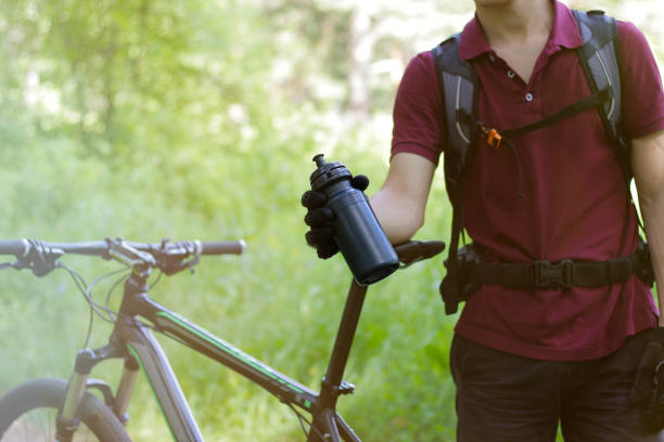 istock Guy on a bike with a bottle outdoors 889362734