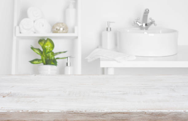 istock Wooden table over blurred spa salon bathroom shelves background 889377876