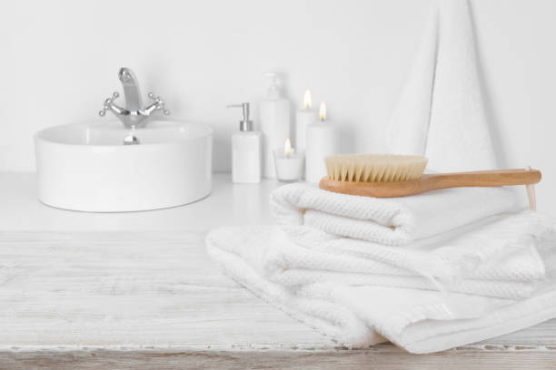 istock White towels on wooden table over blurred simple bathroom background 889378260