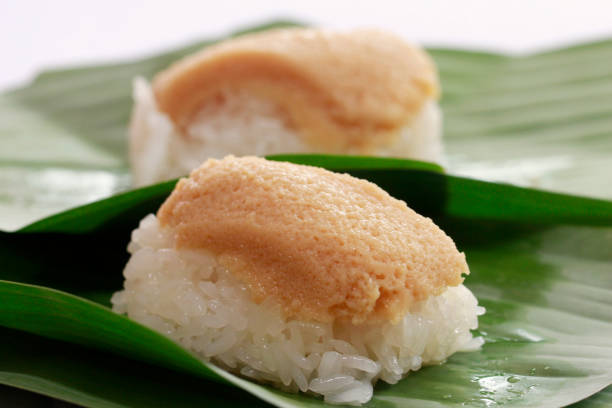istock stick rice  with custard egg on top and warp with banana leaf. 889380888