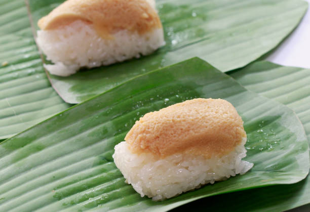 istock stick rice  with custard egg on top and warp with banana leaf. 889380906