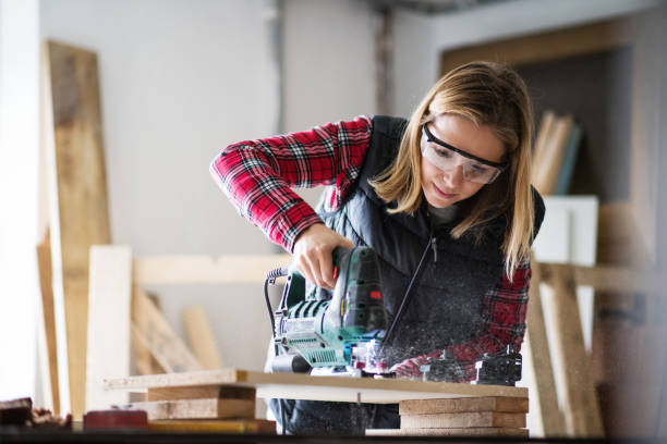 istock Young woman worker in the carpenter workroom. 889409118