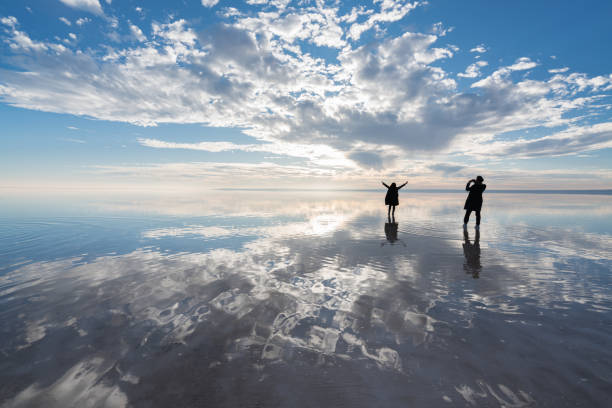 istock Happy young couple having fun walking on salt lake at sunset 889426436