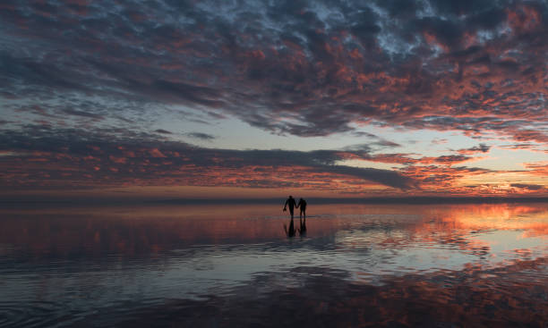 istock Happy young couple having fun walking on salt lake at sunset 889433732