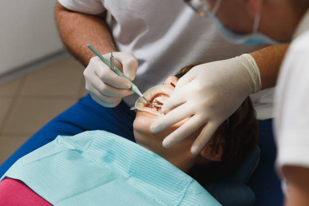 準備とセラミック クラウンをインストール プロセスを閉じます。男性プロの歯科医師は、現代のツール装備クリニック光オフィスで女性患者の歯を治療するのに役立ちます。口を開けて。 - dental light dental equipment hospital professional occupation ストックフォトと画像