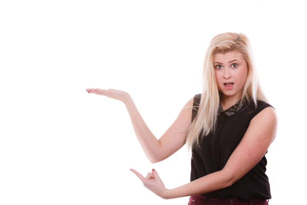 istock Blonde woman pointing with hands at copyspace 889441238
