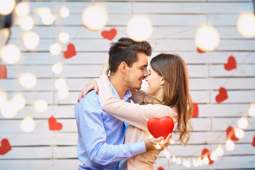 Young man surprising his girlfriend with a gift. Love and affection to close people.