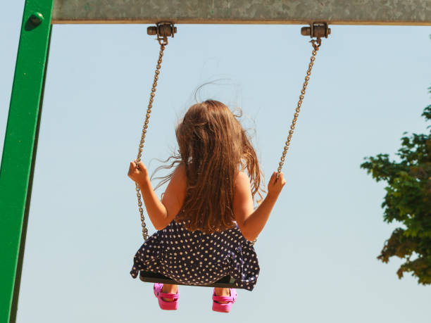 istock Girl swinging on swing-set. 889447258