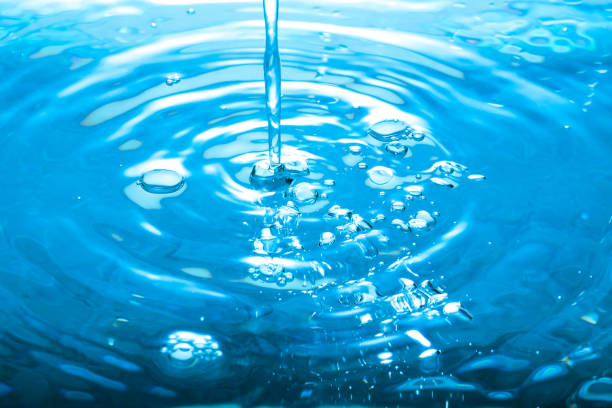 istock Pouring water splashing droplets with bubble and ripples 889454640
