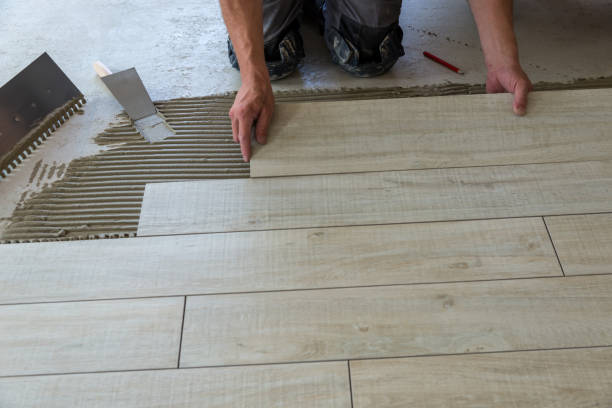 Tiler is laying ceramic tiles. Ceramic tiles in wood look are laid on the floor. Part of the floor is already finished. faux wood stock pictures, royalty-free photos & images