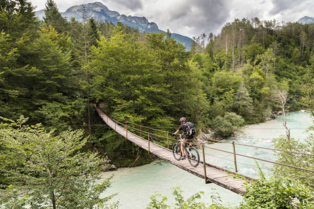 mâle mountainbiker franchit un pont suspendu en slovénie. - slovénie photos et images de collection