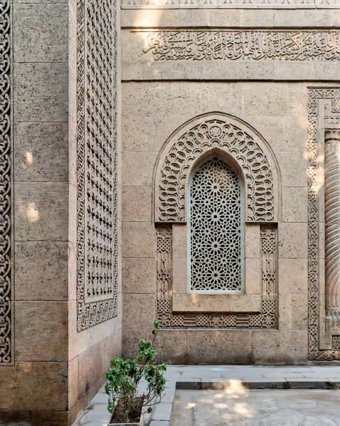 istock Arched window with grid of ornate marble geometric pattern in the bricks stone wall of the mosque of The Manial Palace of Prince Mohammed Ali Tewfik, Cairo, Egypt 889467554