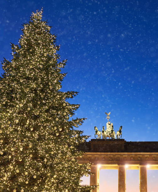 istock Brandenburg Gate in Berlin with Christmas tree and falling snow 889473144