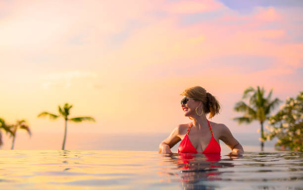 istock Woman enjoying sunset in infinity pool 889473678