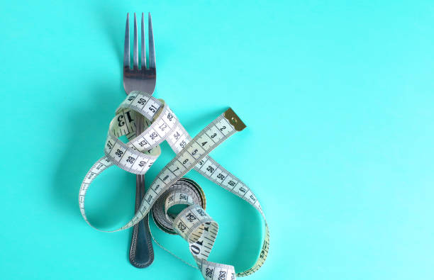 istock Fork with measuring tape. Dieting concept. On blue. 889491428