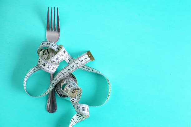 istock Fork with measuring tape. Dieting concept. On blue. 889491590