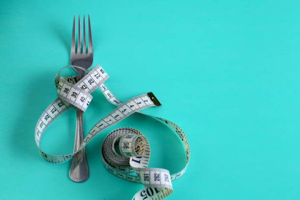 istock Fork with measuring tape. Dieting concept. On blue. 889491854