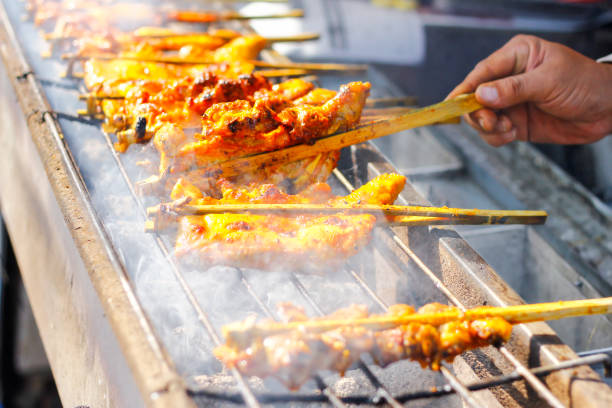 Grilled chicken thigh over flames on a barbecue