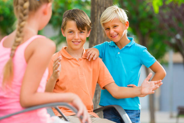 istock Two boys and girl are communicating on walk 889513234