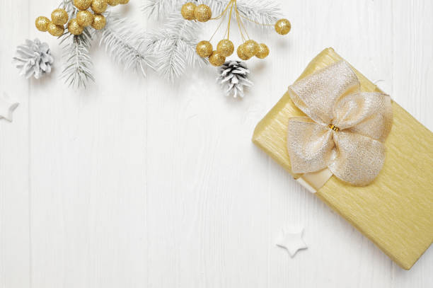 istock Mockup Christmas gift gold bow and tree cone, flatlay on a white wooden background, with place for your text 889521832