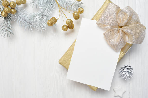 istock Mockup Christmas gift gold bow and tree cone, flatlay on a white wooden background, with place for your text 889521964