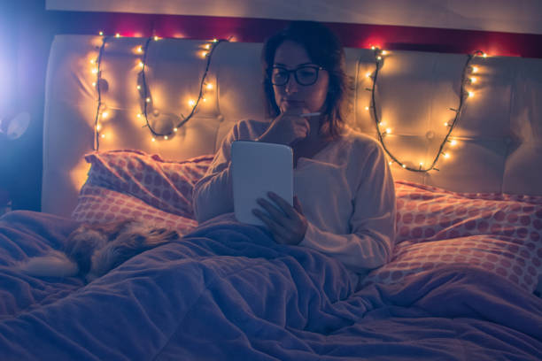 istock Beautiful woman using a tablet in bed before sleep 889529666