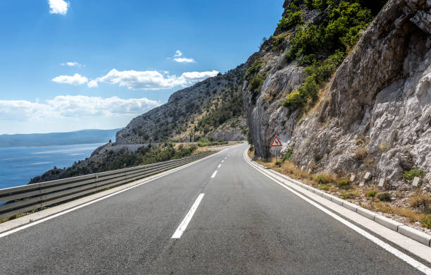 istock Asphalt road to the sea. Asphalt highway in a sunny day 889530708