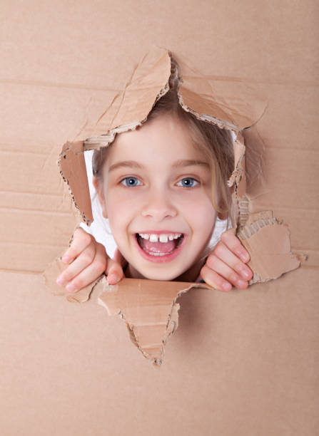 istock kid portrait in torn paper hole 889534482