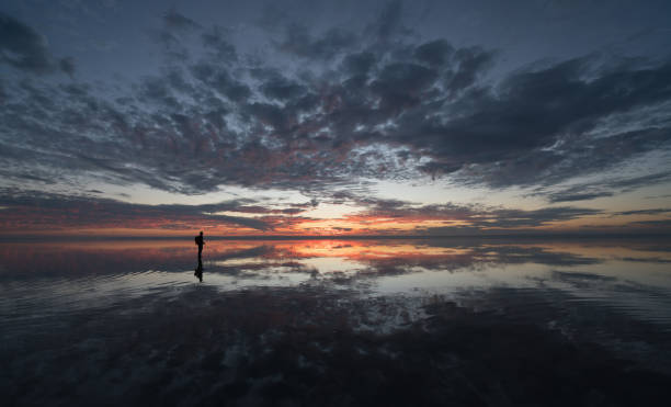 istock Photographer  having fun walking on salt lake at sunset 889537902