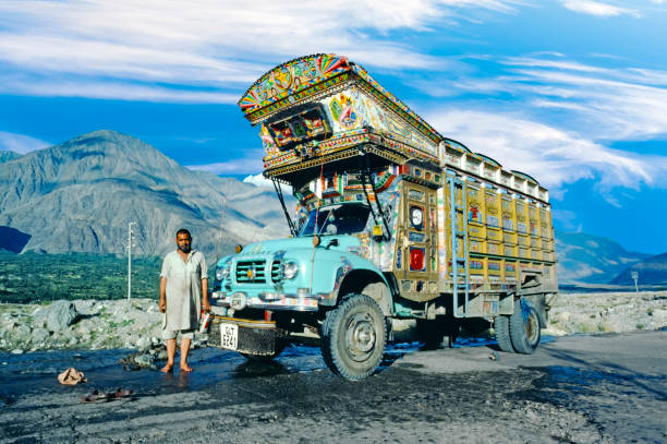proud truck driver presents his painted truck at the karakoram  highway Gilgit: proud truck driver presents his painted truck at the karacorum highway in Pakistan. The Karakoram highway connects Pakistan with China. karakoram highway stock pictures, royalty-free photos & images