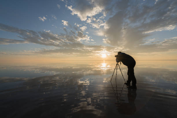istock Photographer  having fun walking on salt lake at sunset 889538448